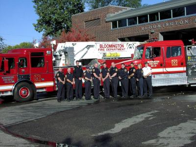 Fire personnel and truck in front of station